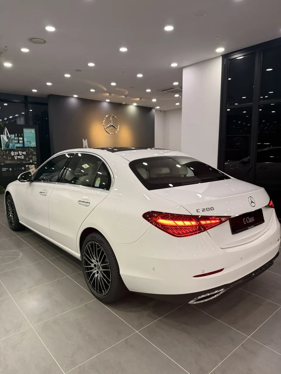 흰색 벤츠 C-Class 세단 후측면과 트렁크의 C 200 배지