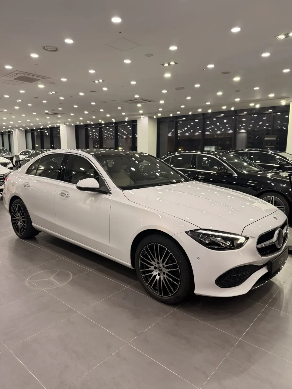 의정부 전시장에 전시된 흰색 벤츠 C-Class 세단의 전면 측면